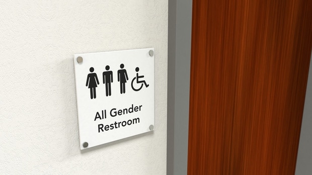 An all gender rest room sign next to a wooden bathroom door; black icons on white background Gender symbols iStock