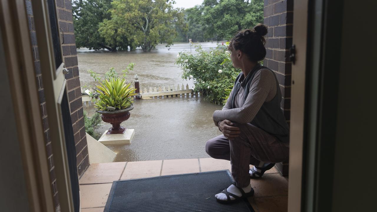 Windsor resident Kelly Miller shows concern as flood waters reach her workplace, a 100 year old property near the Windsor CBD. Picture: Getty Images