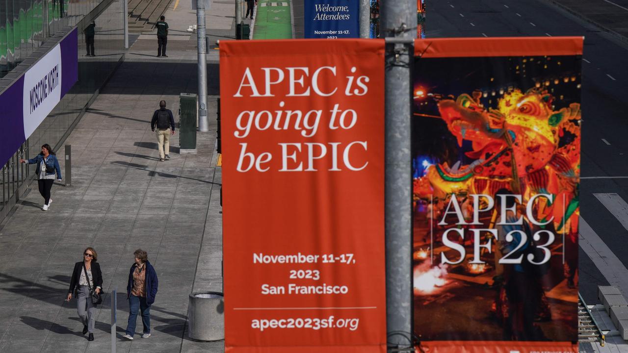 People walk under signage advertising the Asia-Pacific Economic Cooperation (APEC) meetings ahead of the summit at the Moscone Center in San Francisco, California, on November 9, 2023. Picture:Lor en Elliott / AFP