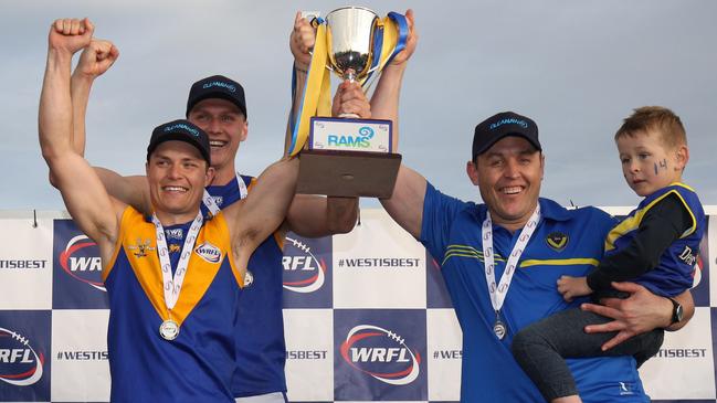 Jake McKenzie, Deer Park captain Jack Purton-Smith and Marc Bullen hoist the silverware after Deer Park defeated Altona in last year’s WRFL Division 1 grand final. Picture: Local Legends Photography