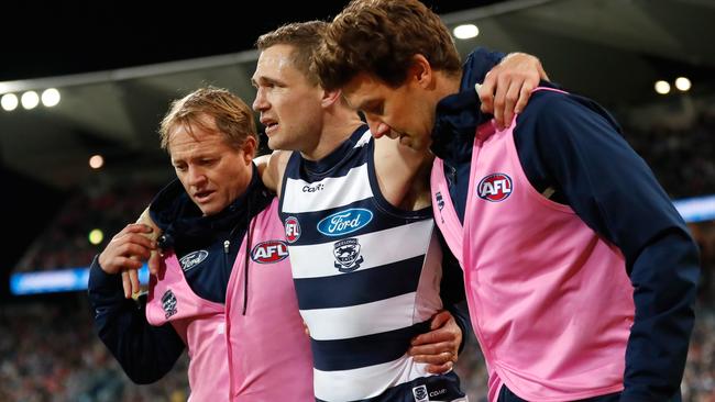 Joel Selwood is helped from the ground after hurting his ankle for the first time.