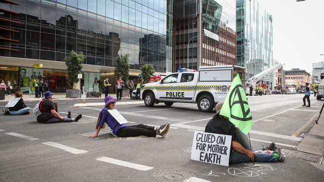 Environmental protesters with their hands glued to the road in the centre of Adelaide. Picture Matt Turner.