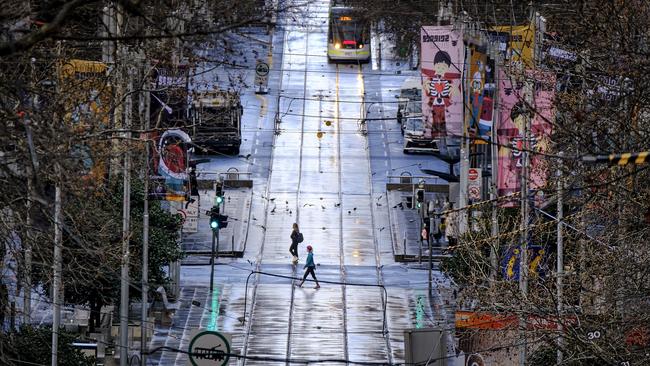 People commute on an empty street in Melbourne during lockdown. Picture: NCA NewsWire / Luis Ascui