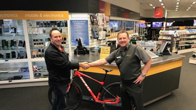 Parkdale Cash Converters manager Craig Brownrigg returning the stolen bike to Jon’s dad Scott Taylor.