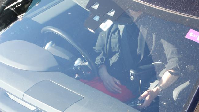 A driver checks their phone while at a set of traffic lights in Frenchs Forest in September this year. Picture by Damian Shaw