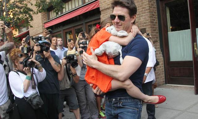 US actor Tom Cruise leaves his hotel carrying daughter Suri for her gymnastics class on July 17, 2012 in New York, NY. Fairytale Hollywood couple Tom Cruise and Katie Holmes last month announced they were calling it quits after five years of marriage, ending an unexpected love story dogged by tabloid rumors. AFP PHOTO / Mehdi Taamallah