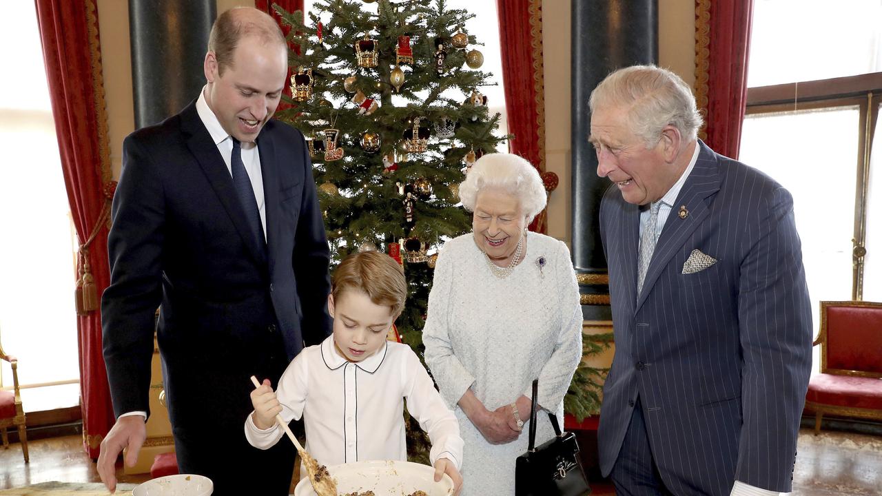 In this undated photo provided by Buckingham Palace, Britain's Queen Elizabeth, Prince Charles, Prince William and Prince George smile as they prepare special Christmas puddings in the Music Room at Buckingham Palace, London, as part of the launch of The Royal British Legion's Together at Christmas initiative. (Chris Jackson/Buckingham Palace via AP)