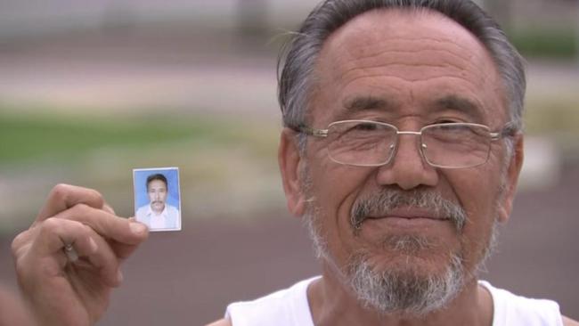 Recently released detainee Aliyawar Yawari holding a picture of himself taken prior to being placed in detention. Picture: 7 News