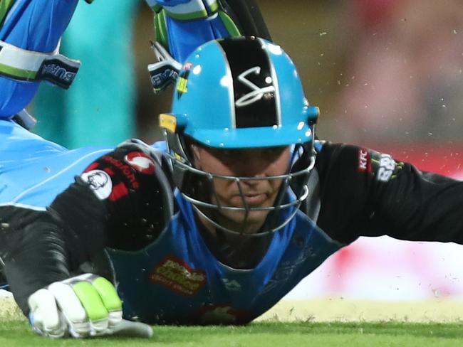 BRISBANE, AUSTRALIA - DECEMBER 19:  Alex Carey of the Strikers dives during the Big Bash League match between the Brisbane Heat and the Adelaide Strikers at The Gabba on December 19, 2018 in Brisbane, Australia. (Photo by Chris Hyde/Getty Images)