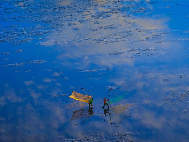 Jingyi Wang: During low tide two fishers use their traditional fishing nets to scoop up their catch. China