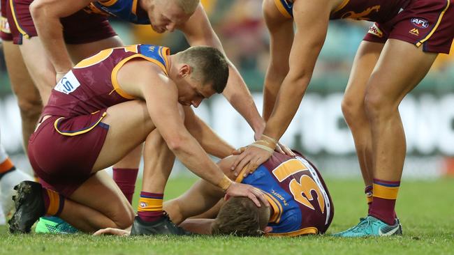 Teammates check on Harris Andrews after being knocked out.