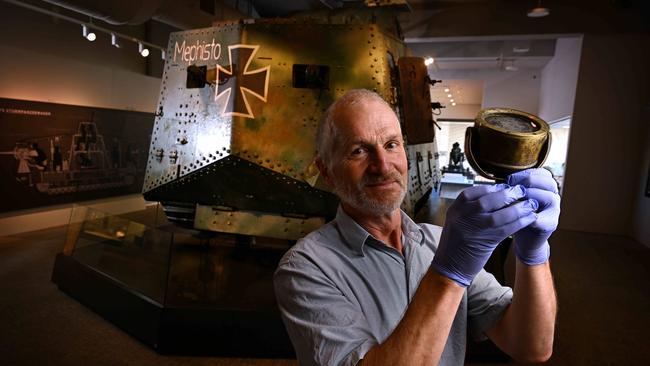 The worlds only remaining German WW1 tank is reunited with its long lost compass by Tom Lamin, inside the Queensland Museum. Picture: Lyndon Mechielsen