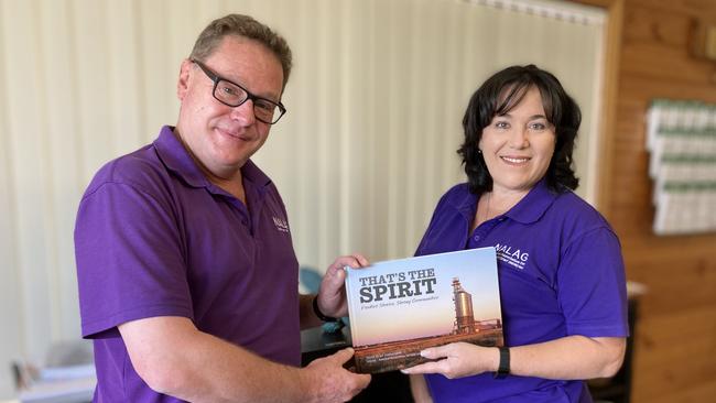 Mr O’Leary and Ms Todkil with a book NALAG board member Jen Cowley created to promote resilience and empower country communities battling drought. Picture: Ryan Young