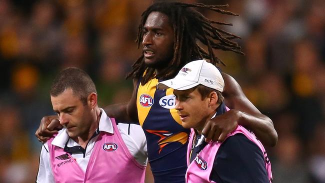 Nic Naitanui is helped off Subiaco after injuring his knee.