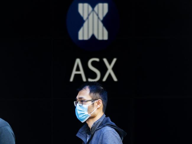 SYDNEY, AUSTRALIA - MARCH 13: A man in a mask is seen in front of The Australian Stock Exchange logo on March 13, 2020 in Sydney, Australia. The ASX200 plunged more than 7 percent in the first 15 minutes of trade on Friday, amid fears over the spread of COVID-19. The Australian sharemarket fall follows the worst day of trading on Thursday, which saw the worst losses since the Global Financial Crisis. (Photo by Jenny Evans/Getty Images)