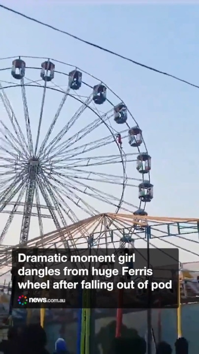 Terrifying moment teen dangles from ferris wheel