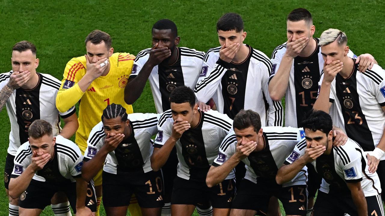 Germany's players cover their mouths as they pose for a group picture before the game against Japan.