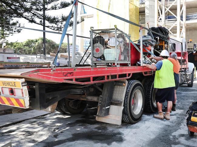 Builders collecting tools and equipment , being watched by security, and leaving the Midwater building site at Main Beach . Picture Glenn Hampson