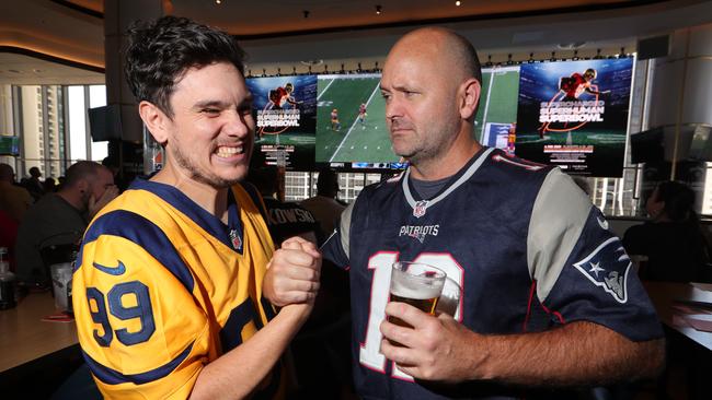 Opposing fans, Rams fan Malen Franks from Pacific Pines and Patriots fan Nathan McMahon from Reedy Creek, cross paths during Super Bowl celebrations at The Star. Picture Glenn Hampson