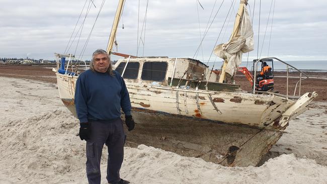 Novice sailor Claude Evans with his stranded yacht at North Haven. Picture:, Colin James