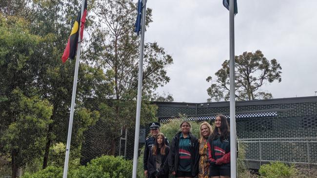 Warrandyte police's Stuart Henderson with Charli, 15, Shawna and Tarini, both 14, and Victoria Police's outer east Aboriginal community liaison Selina Grizos at the flag raising ceremony at Warrandyte police station on November 23, 2021. Picture: Kiel Egging.