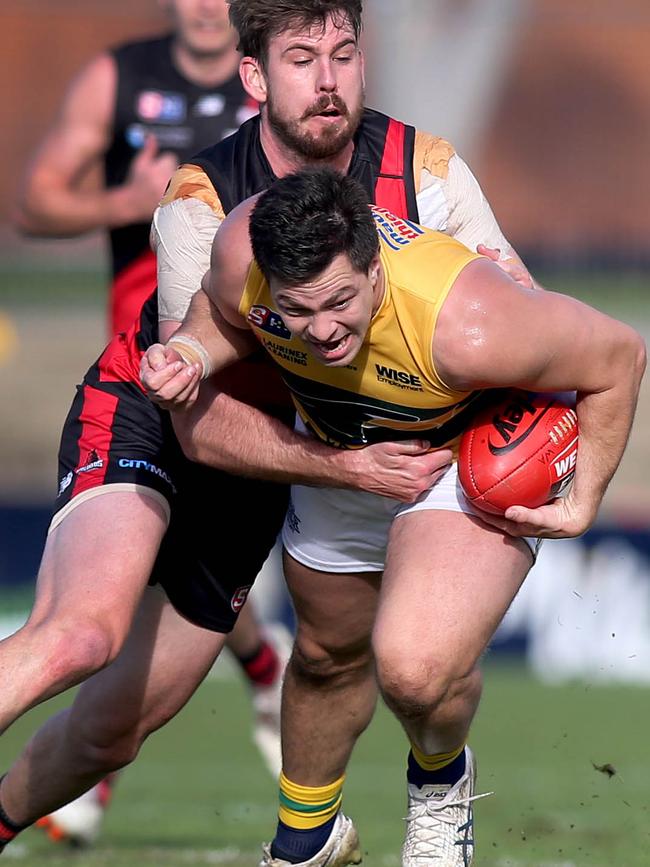 Eagle Jesse Lonergan tries to break the tackle of West Adelaide’s Kaiden Brand during the game at Richmond Oval on Saturday. Picture: Dean Martin