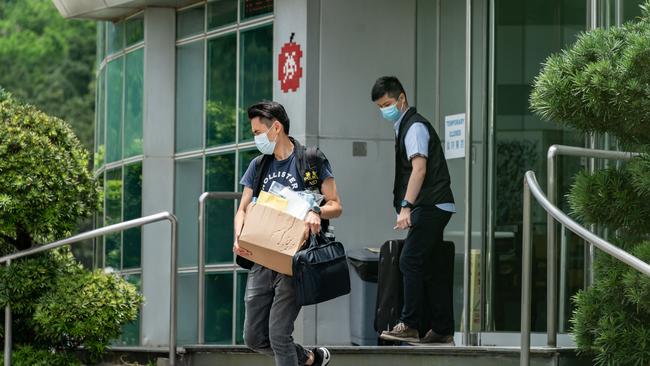 Police carry evidence they sized from the headquarters of the Apple Daily newspaper.