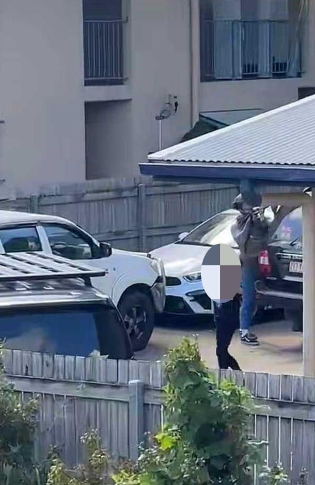 A woman surrenders to armed Townsville Police officers after a raid at an address in Nix Street in the West End on Friday afternoon. Picture: Supplied