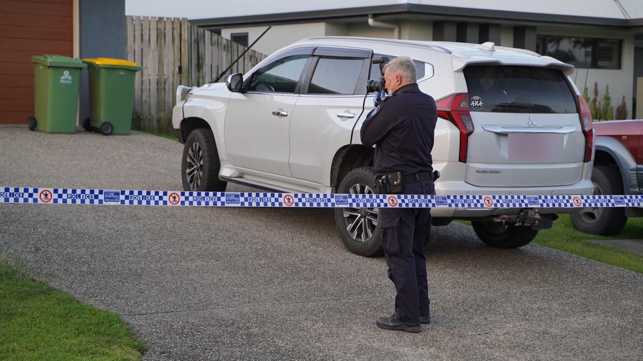 Police officers could be seen taking photographs of a rubbish bin, the side fence, and shelving inside the Glenella home where a mother’s death was declared as suspicious. Picture: Heidi Petith