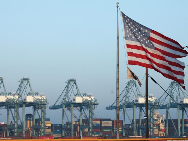 SAN PEDRO, CALIFORNIA - NOVEMBER 07: An American flag flies nearby with shipping containers stacked at the Port of Los Angeles in the background, which is the nation's busiest container port, on November 7, 2019 in San Pedro, California. Port officials said today October cargo volume was down 19 percent this year compared with October 2018 due to tariffs imposed in the U.S.-China trade war. The Port of Los Angeles along with neighboring Port of Long Beach are the United States' main gateways for trade with Asia. (Photo by Mario Tama/Getty Images)