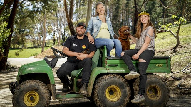 Marc and Rhiann Webb with daughter Estelle, 12, and dogs Rory and Duke on the site where their old place burnt down and the new house will be built. Picture: Mike Burton