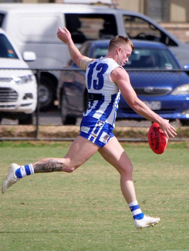 Tim McGenniss takes a kick for Langwarrin. Pic: Paul Churcher.