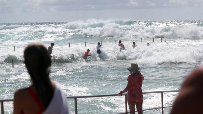 Locals watch on at Curl Curl on Sydney’s northern beaches as a wave surges inside an ocean pool caused by big swells along the coast. Picture: Richard Dobson