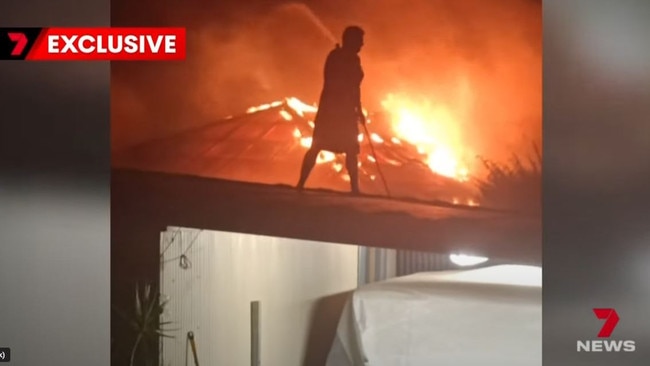 Footage emerged of the firefight by neighbour Michael Payne on his fence trying to contain the blaze. Picture: 7NEWS