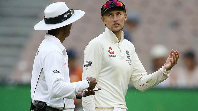 England skipper Joe Root talks with the umpire as the players walk off for another rain delay. Picture: Michael Klein.