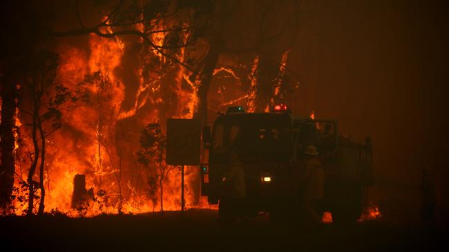 NSW Fire and Rescue Firefighters evacuating an out of control fire where houses were lost near Khappinghat National Park south Taree. Picture: Jane Dempster