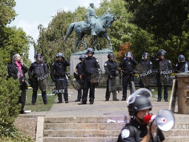 Virginia State Police in riot gear guard the statue of Robert E Lee. Picture: AP Photo/Steve Helber