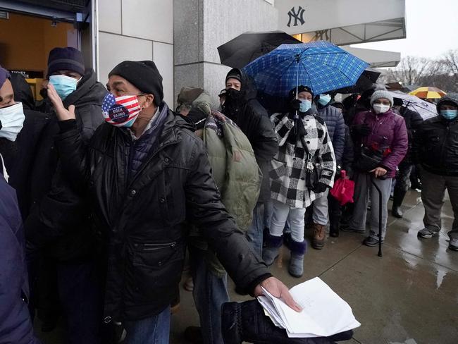 People line up in the rain outside the Yankee Stadium which has been turned into a mass vaccination site. Picture: AFP.