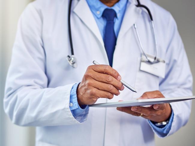 Shot of an unrecognizable male doctor writing on a digital tablet while standing inside of a hospital during the day    istock image