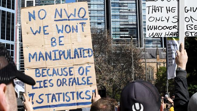 A protester in June holding up signs about the “NWO” or “New World Order”. Picture: Matrix Media