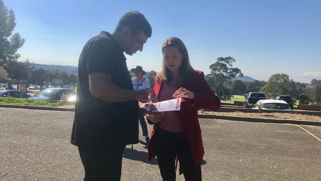 Ms Champion speaking to voters outside the Elizabeth Macarthur High School polling station.