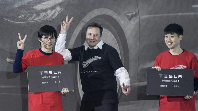 Elon Musk poses with Tesla owners at a ceremony for the first Tesla Model 3 cars made at Tesla's Shanghai factory. Picture: AP