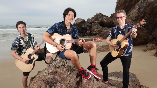 Bobby Holmes right at home following the release of his new single about surfing and the Gold Coast. The Holmes family, brothers Angus and Bobby, with father Brad. Picture Glenn Hampson