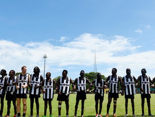 Players line up before the Tiwi Islands Football League grand final. PICTURE: Elise Derwin