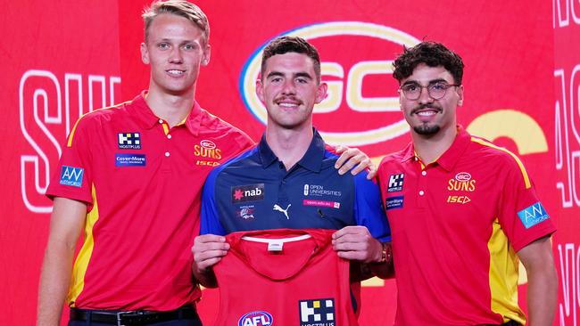 Sam Flanders is presented with a jersey by Jack Lukosius (left) and Izak Rankine of the Suns (right) during the first round of the 2019 AFL Draft at Marvel Stadium in Melbourne, Wednesday, November 27, 2019. (AAP Image/Michael Dodge) NO ARCHIVING