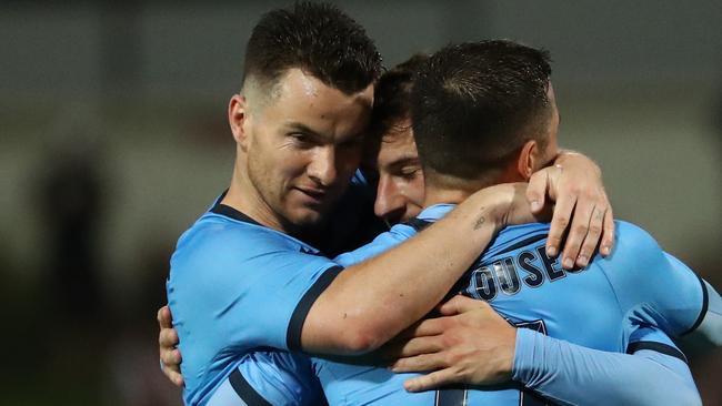 Alex Baumjohann celebrates a goal with Sydney FC teammates Kosta Barbarouses and Adam Le Fondre.