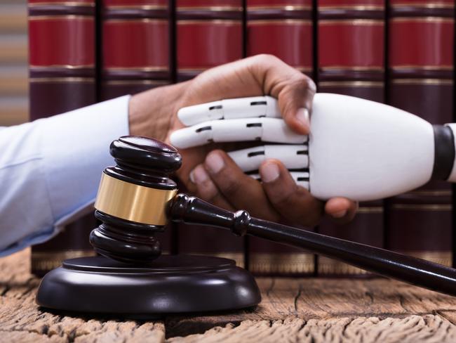 CAREERS: robot lawyer. iStockGavel And Mallet In Front Of Man Shaking Hand With Robot Over The Wooden Desk