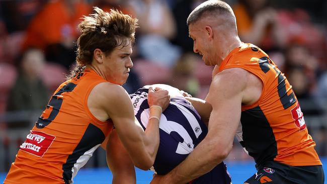 Giants Aaron Cadman and Jesse Hogan tackle Fremantle's Brandon Walker during the AFL Round 23 match between the GWS Giants and Fremantle Dockers at Engie Stadium on August 17, 2024. Photo by Phil Hillyard(Image Supplied for Editorial Use only - **NO ON SALES** - Â©Phil Hillyard )