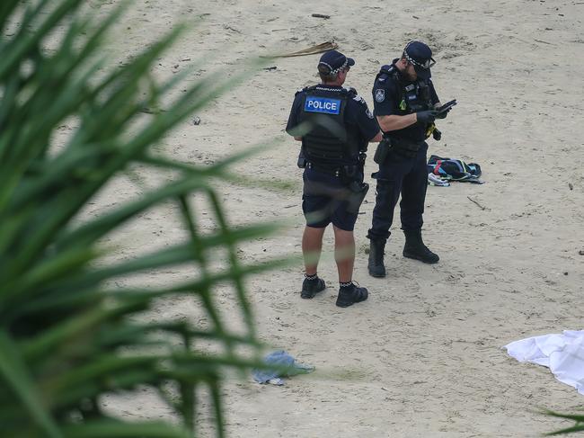 Queensland Police attend the scene where the body of a swimmer was found on Froggys Beach.Picture: Glenn Campbell