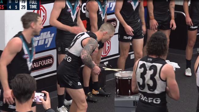 Hartlett leads the Port Adelaide team song with a drum kit.